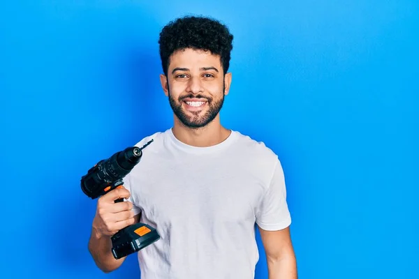 Young Arab Man Beard Using Drill Looking Positive Happy Standing — Stockfoto