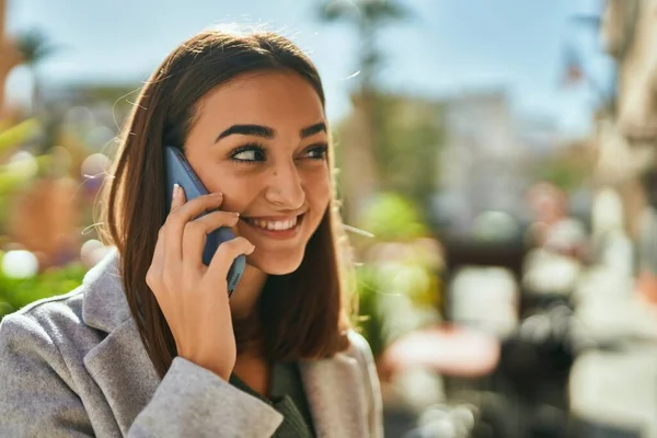 若いですヒスパニック系の女の子笑顔幸せな話上のスマートフォンで街 — ストック写真