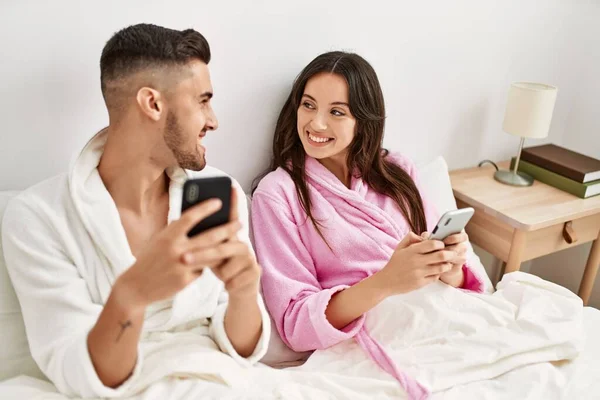 Jong Hispanic Paar Met Behulp Van Smartphone Liggend Bed Thuis — Stockfoto