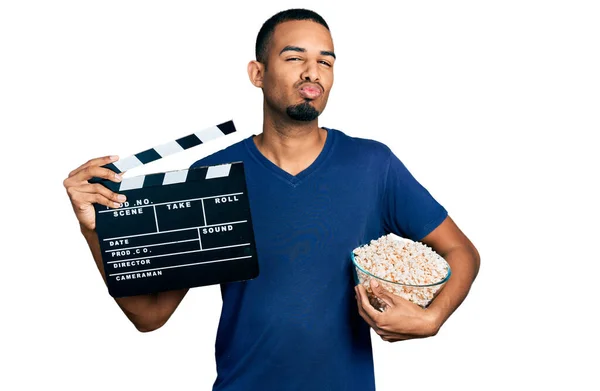Giovane Uomo Afroamericano Mangiare Popcorn Tenendo Pellicola Clapboard Guardando Fotocamera — Foto Stock