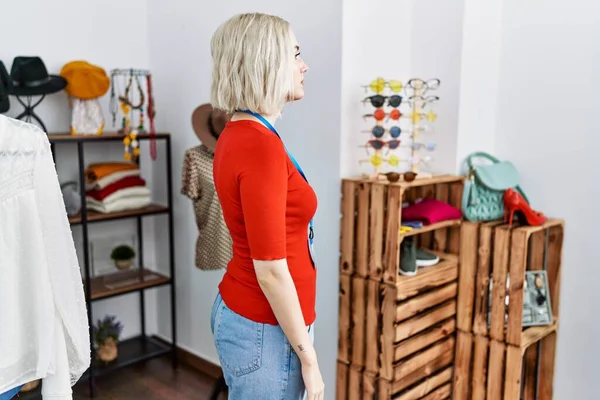 Perakende satış mağazasında yönetici olarak çalışan genç beyaz bir kadın. Taraf arıyor, rahat profil pozu veriyor. Kendine güvenen bir gülümsemesi var.. 