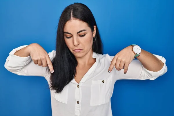 Jonge Spaanse Vrouw Die Een Blauwe Achtergrond Staat Naar Beneden — Stockfoto