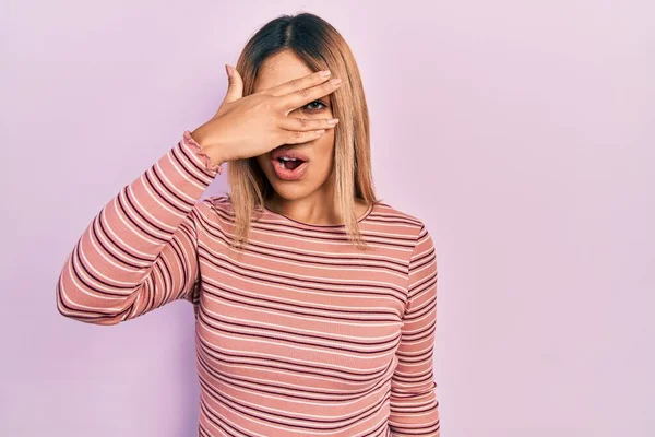 Beautiful Hispanic Woman Wearing Casual Striped Sweater Peeking Shock Covering — Zdjęcie stockowe