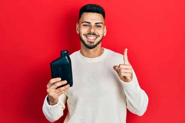 Young Hispanic Man Beard Holding Motor Oil Bottle Smiling Idea — Stockfoto