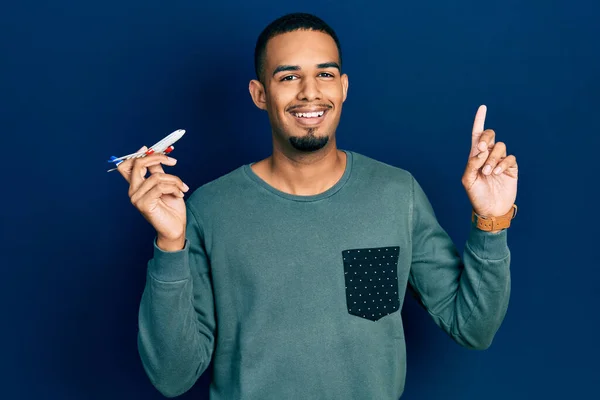 Ung Afrikansk Amerikansk Man Håller Flygplan Leksak Förvånad Med Idé — Stockfoto