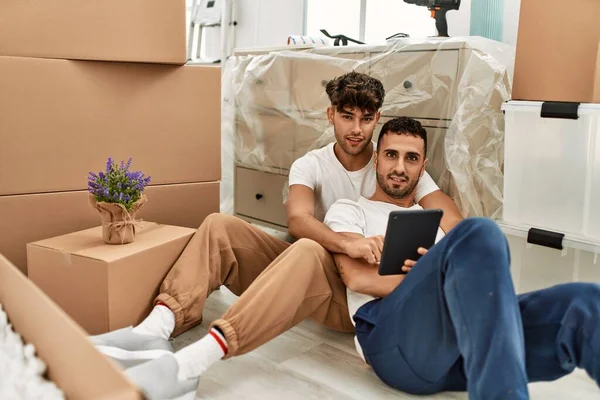 Dos Hombres Hispanos Pareja Sonriendo Confiados Usando Touchpad Nuevo Hogar — Foto de Stock