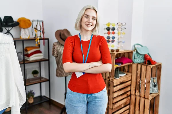 Perakende mağazasında yönetici olarak çalışan beyaz bir kadın kollarını kavuşturup kameraya bakarak gülümsüyor. pozitif kişi. 