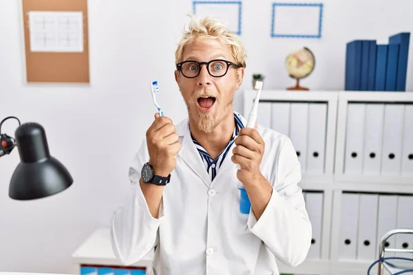 Jonge Blonde Man Werkt Bij Tandarts Kliniek Met Elektrische Tandenborstel — Stockfoto
