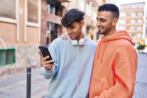 两个男人在街上用智能手机互相拥抱 — 图库照片