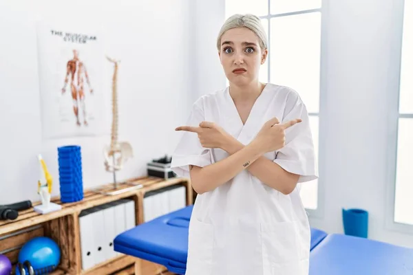 Молодая Белая Женщина Работающая Клинике Болеутоляющих Указывая Пальцами Обе Стороны — стоковое фото