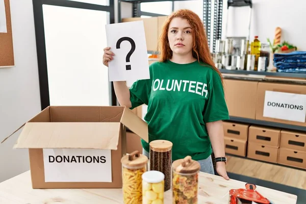 Young Redhead Woman Wearing Volunteer Shirt Holding Question Mark Thinking — Foto de Stock