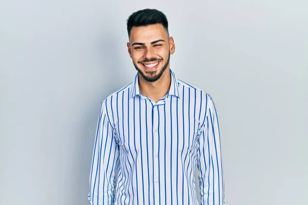 Young Hispanic Man Beard Wearing Casual Striped Shirt Winking Looking — Foto de Stock