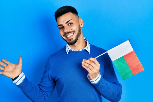 Young Hispanic Man Beard Holding Madagascar Flag Celebrating Achievement Happy —  Fotos de Stock