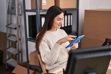 Ofiste dokunmatik ped kullanan genç bir iş kadını.