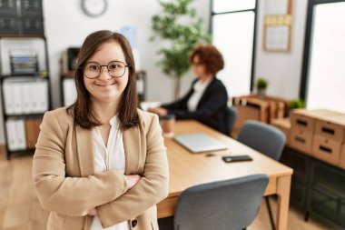 Down sendromlu kız takım çalışması yapıyor. Ofiste çalışan iki kadın grubu.