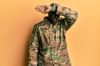 Afrika kökenli genç bir Amerikalı asker asker üniforması giyiyor. Gözleri kollarıyla kapatıyor. Ciddi ve üzgün görünüyor. Görme, saklama ve reddetme konsepti 