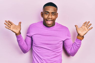 Sıradan pembe kazak giyen genç bir adam çılgın ve başarıyı kollarını kaldırıp heyecanla haykırarak kutluyor. Kazanan konsept 