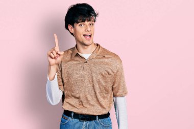 90 'ların modası geçmiş yakışıklı genç adam bir fikir ya da soruyla gülümsüyor ve mutlu bir yüzle işaret ediyor. 