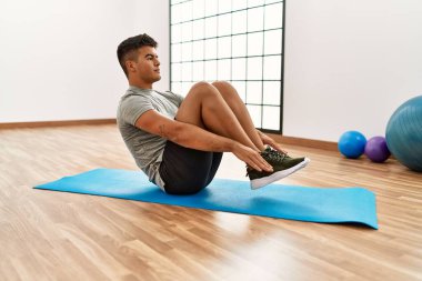 Spor merkezinde karın kaslarını çalıştıran genç bir İspanyol.