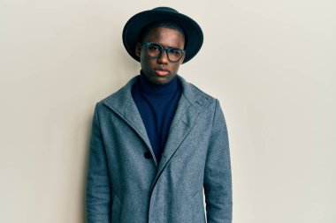 Genç Afro-Amerikan erkeği zarif bir stil giyiyor şüpheci ve gergin, sorun yüzünden surat asıyor. negatif kişi. 