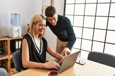 Ofiste dizüstü bilgisayarla çalışırken gülümseyen iki iş adamı..