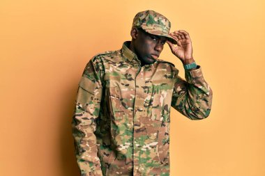 Asker üniforması giyen genç Afro-Amerikalı adam, alnındaki bir sorunla ilgili endişeli ve stresli, bunalımda ve endişeli. 