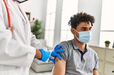 Genç doktor kadın erkek için covid-19 koronavirüs aşısı yapıyor..