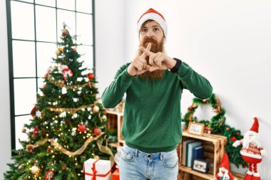 Kızıl saçlı, uzun sakallı, noel şapkası takan, Noel ağacından reddedilmiş bir adam. 