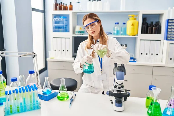 Young Blonde Woman Wearing Scientist Uniform Pouring Liquid Test Tube — Stock fotografie