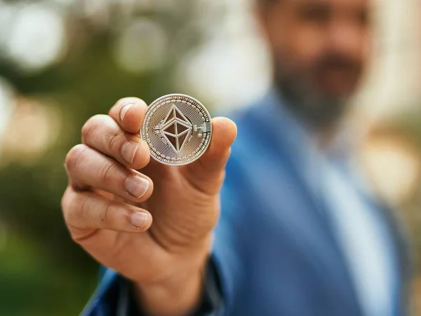 Średniowieczny Biznesmen Trzymający Ethereum Crypto Coin Stojący Mieście — Zdjęcie stockowe