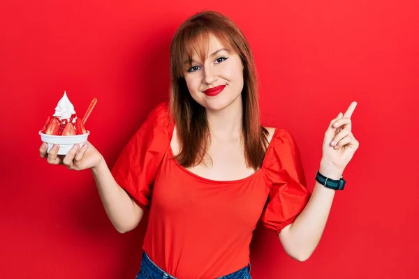 Ruiva Jovem Segurando Sorvete Sorrindo Feliz Apontando Com Mão Dedo — Fotografia de Stock