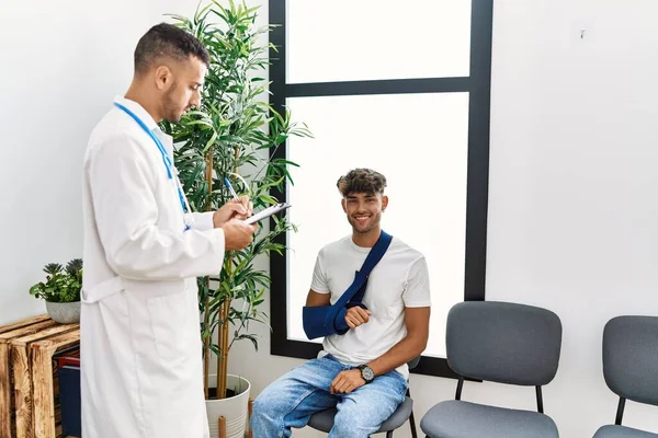 Two Hispanic Men Doctor Patient Writing Clipboard Sitting Chair Hospital — Stock Photo, Image