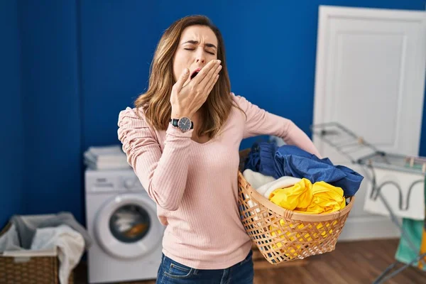 Young Woman Holding Laundry Basket Bored Yawning Tired Covering Mouth — ストック写真