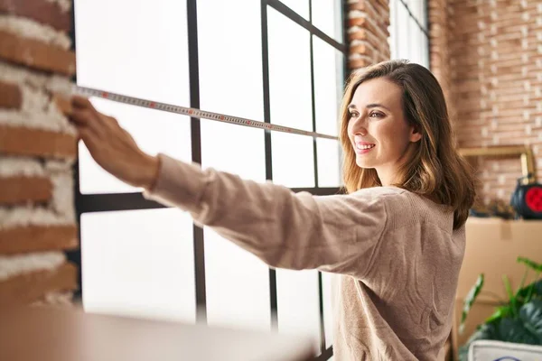 Genç bir kadın yeni evindeki kendinden emin ölçüm penceresine gülümsüyor.