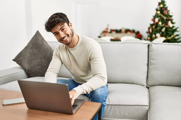 Молодий Іспаномовний Чоловік Посміхається Щасливий Сидячи Дивані Використовуючи Ноутбук Вдома — стокове фото