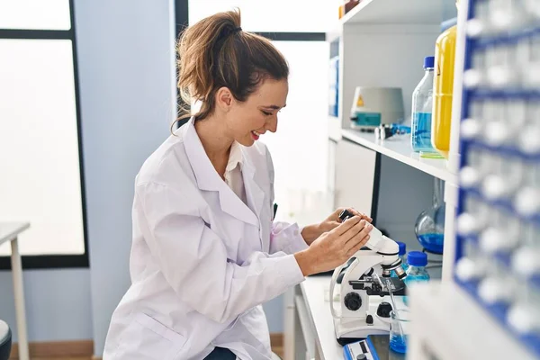 Young Woman Wearing Scientist Uniform Using Microscope Laboratory — стоковое фото