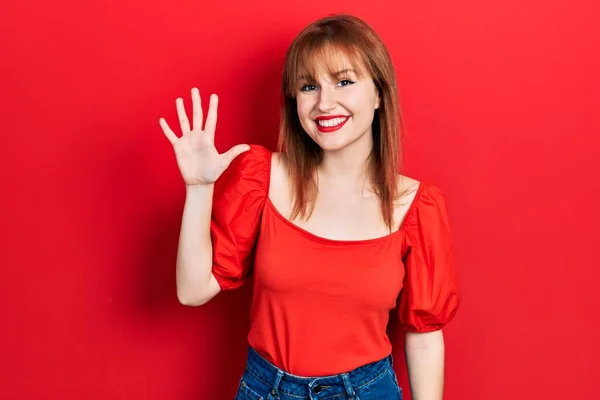 Kırmızı Tişörtlü Kızıl Saçlı Genç Bir Kadın Beş Numarayı Gösterip — Stok fotoğraf