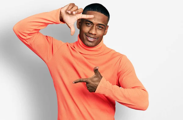 Young Black Man Wearing Orange Turtleneck Sweater Smiling Making Frame — Stok fotoğraf