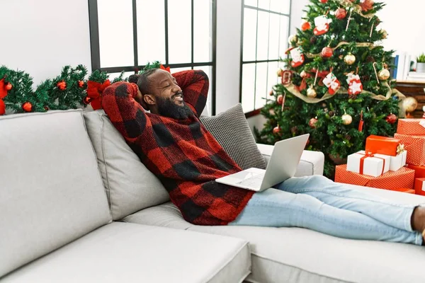 Young African American Man Relaxed Hands Head Sitting Christmas Tree — стокове фото