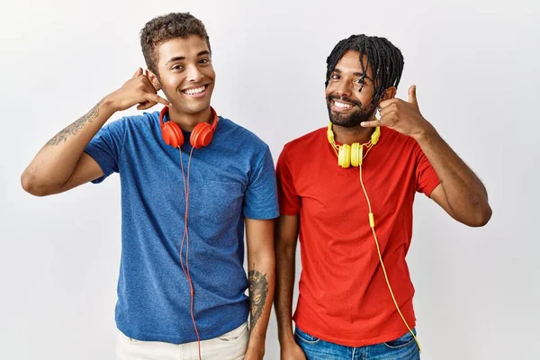 Young Hispanic Brothers Standing Isolated Background Wearing Headphones Smiling Doing — Stok fotoğraf