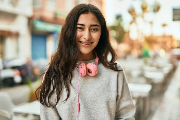 Ortadoğulu Genç Kız Şehirde Kulaklık Takarak Mutlu Bir Şekilde Gülümsüyor — Stok fotoğraf