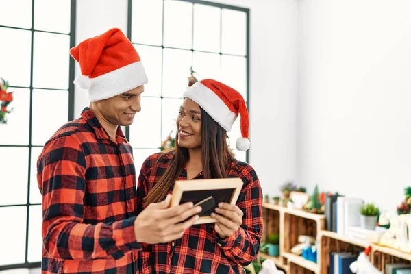 Young Latin Couple Celebrating Christmas Holding Frame Home — Stock Fotó