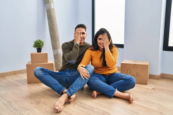 Young Couple Sitting Floor New Home Covering One Eye Hand — 스톡 사진