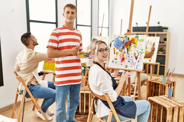 アートスタジオで笑顔で絵を描く人々のグループ — ストック写真
