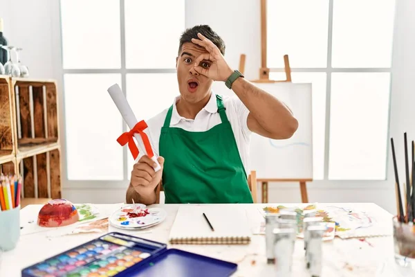 Young Hispanic Man Art Studio Holding Degree Doing Gesture Shocked — Stock Photo, Image