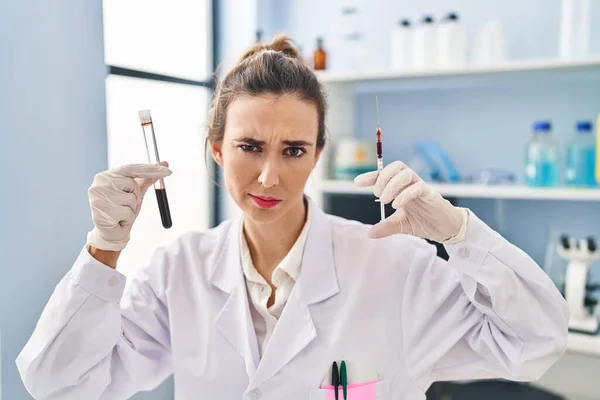 Νεαρή Γυναίκα Που Εργάζεται Εργαστήριο Επιστημόνων Κρατώντας Δείγμα Αίματος Σκεπτικιστής — Φωτογραφία Αρχείου
