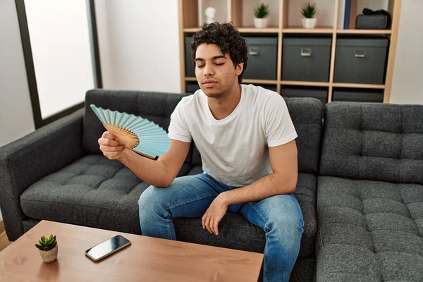 Jeune Homme Hispanique Utilisant Ventilateur Main Assis Sur Canapé Maison — Photo