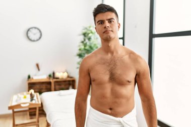 Spa merkezinde üstsüz dikilen İspanyol genç adam yüzünde ciddi bir ifadeyle rahatladı. Basit ve doğal bir şekilde kameraya bakıyorsun.. 