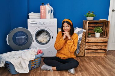 Genç İspanyol kadın çamaşırlarını yıkıyor. Gergin ve heyecanlı bir şekilde çenesi yana bakıyor. 