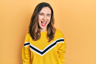 Gündelik kıyafetler giyen genç İspanyol kız kameraya seksi bir ifadeyle bakıyor, neşeli ve mutlu bir yüzle.. 